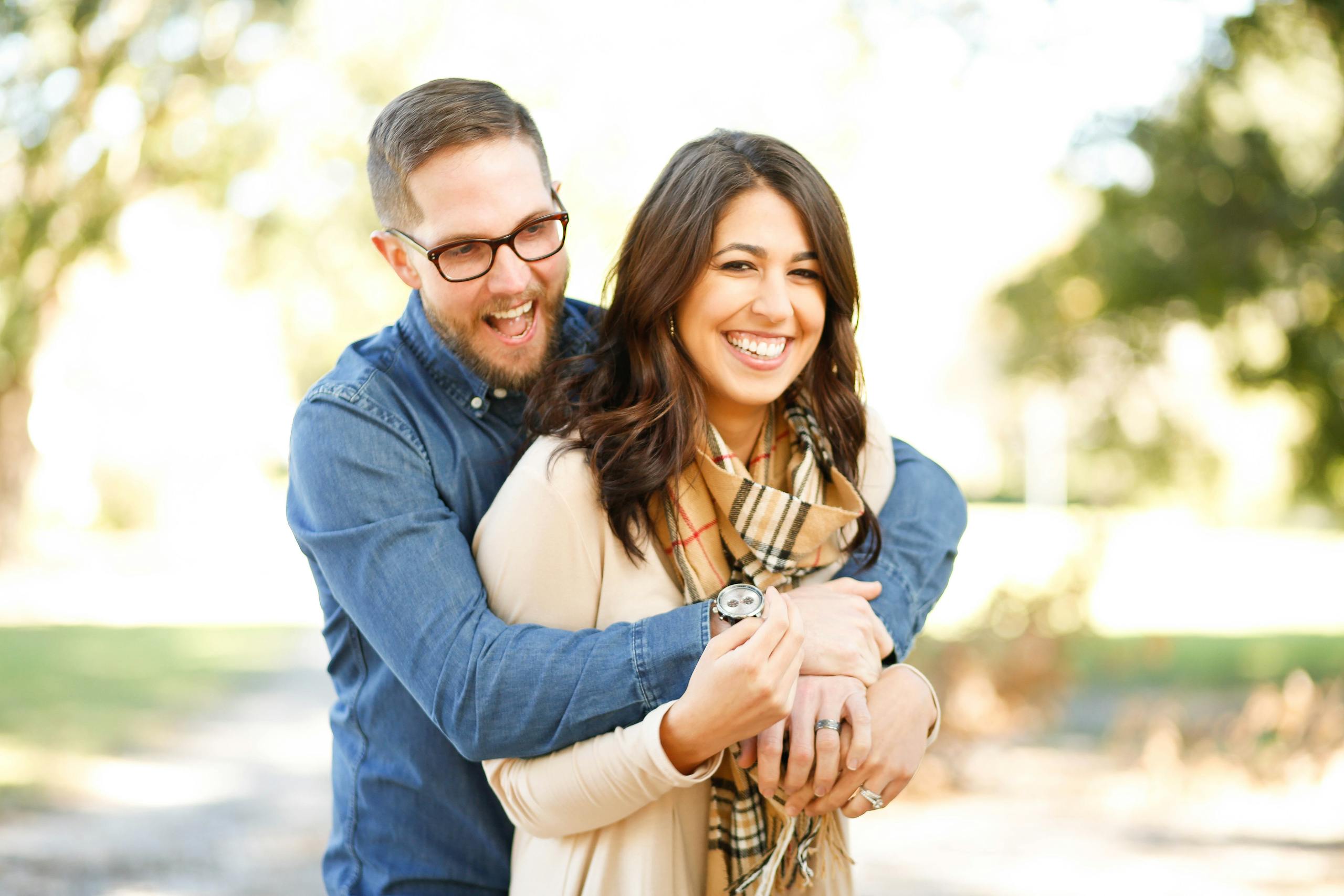 A happy couple enjoying an outdoor moment with laughter and love.