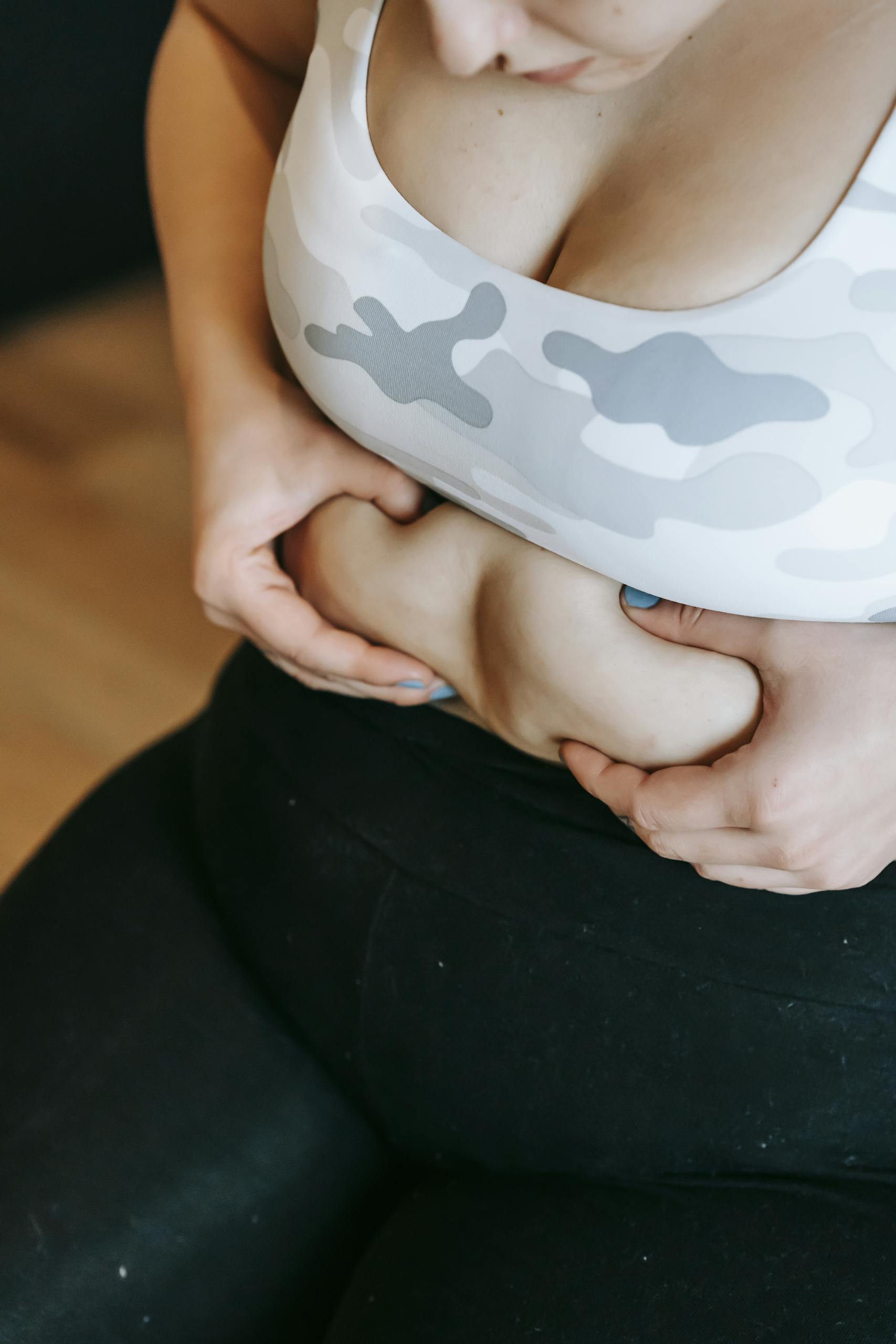 Close-up of a woman embracing her body during a workout in the gym.